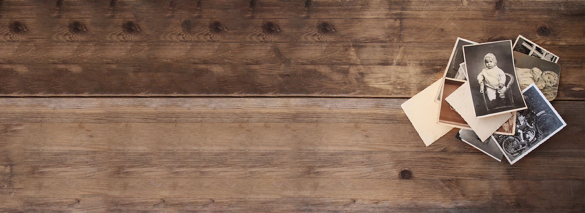 Old family photographs on rustic wooden table for photo scanning and digitization by DVD Your Memories Los Angeles.