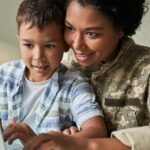 A parent showing their child some memories on a laptop.