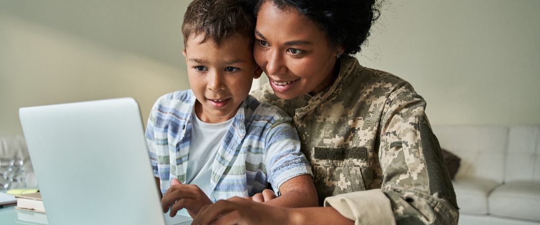 A parent showing their child some memories on a laptop.