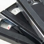 Stack of unlabeled VHS tapes on a white background
