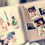 Someone looking through an old scrapbook full of photos.