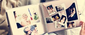 Someone looking through an old scrapbook full of photos.