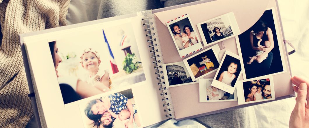 Someone looking through an old scrapbook full of photos.