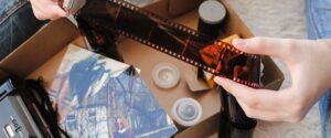 Someone looking through an old photo box and finding canisters of negatives.