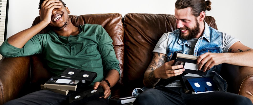 Two people reminisce and look at old family video tapes together.