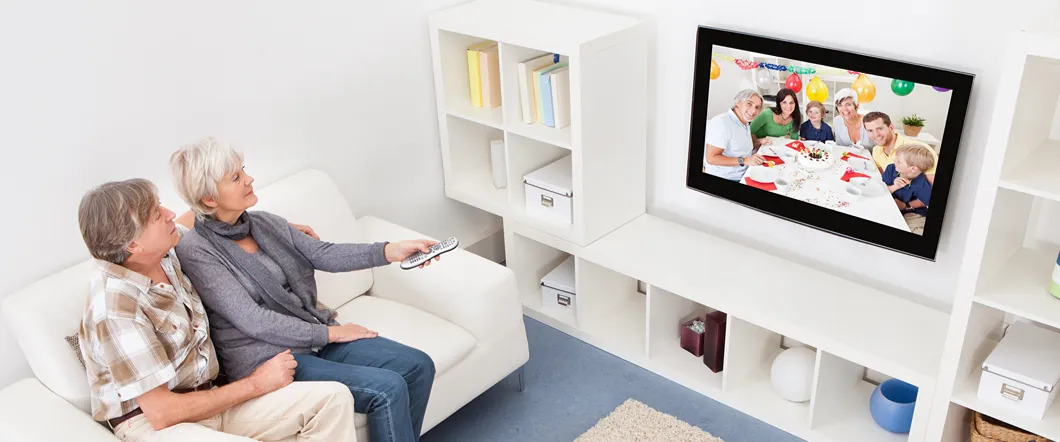 People on a couch watching a digitized home movie