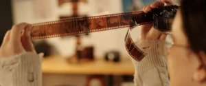 Someone looking at old film negatives that have faded.