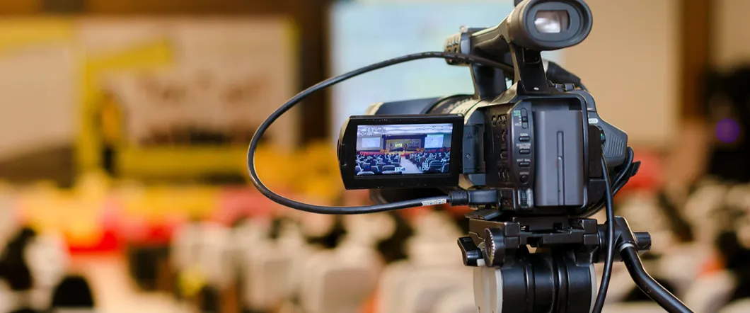 Will My Camcorder Tape Dates Be Preserved After Digitization? Someone filming on an old film camcorder, with dates visible.