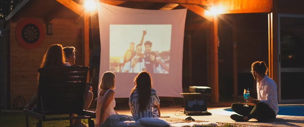A family watches as a film is projected onto a white screen.